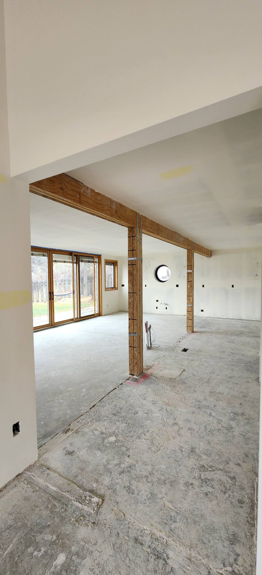 Freshly installed drywall in open-plan space with exposed beam