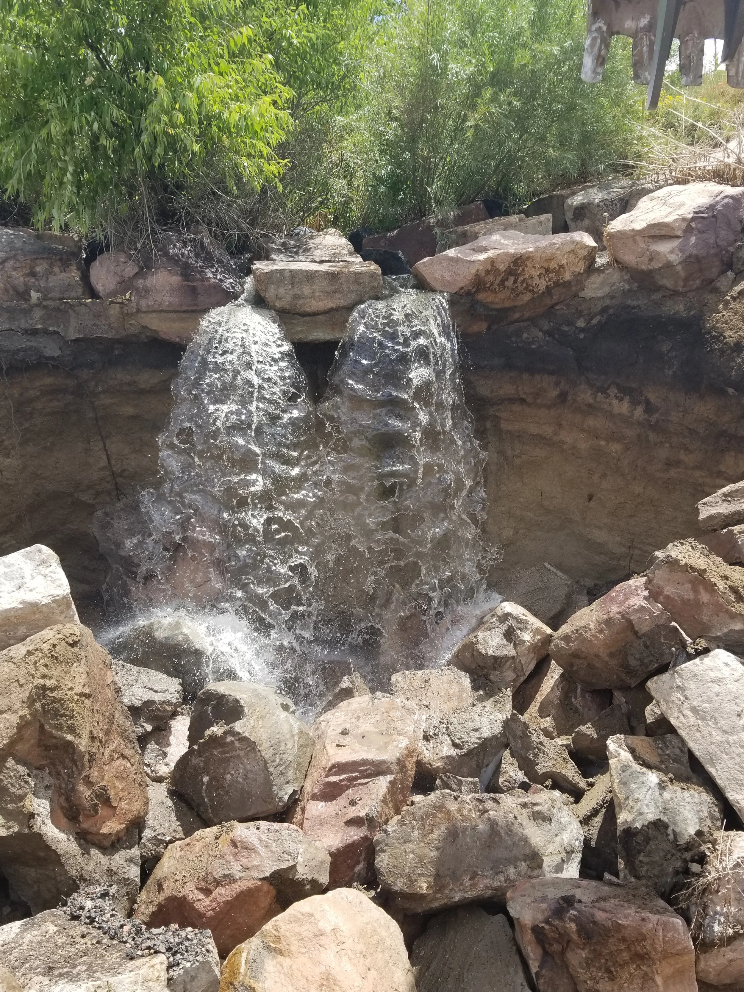 Boulder scaping project with waterfall flowing over natural rocks