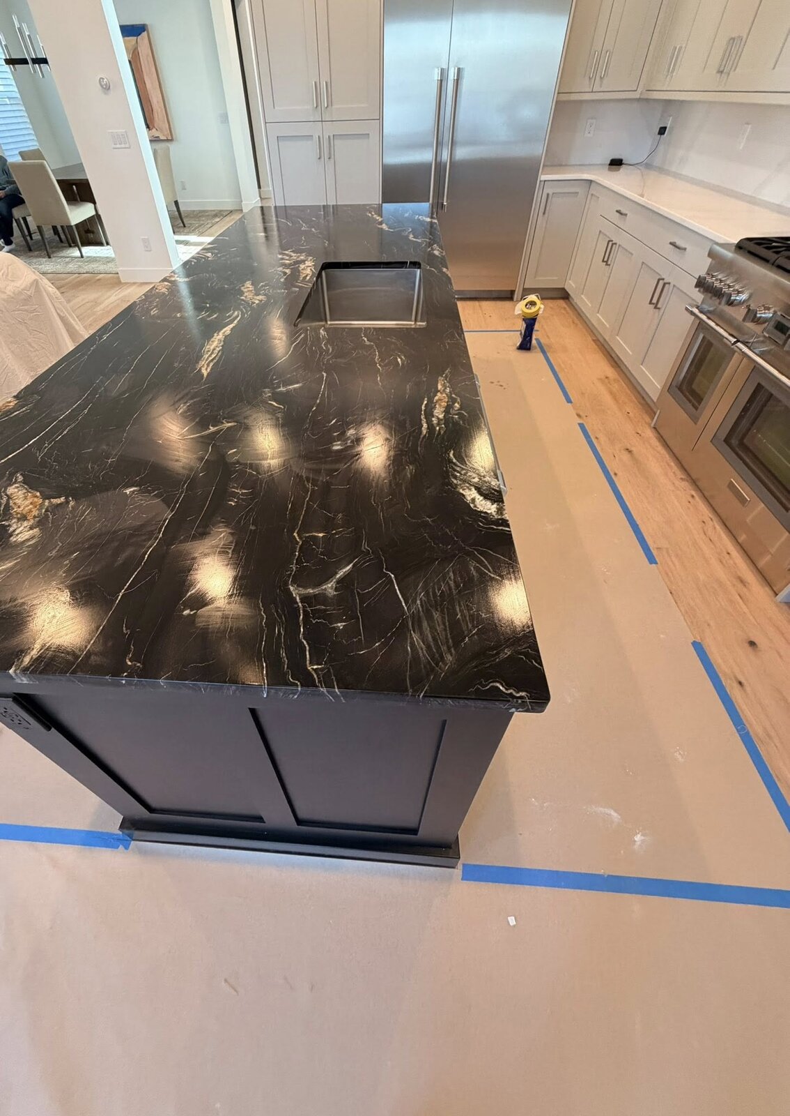 Black granite island in white-cabinet kitchen