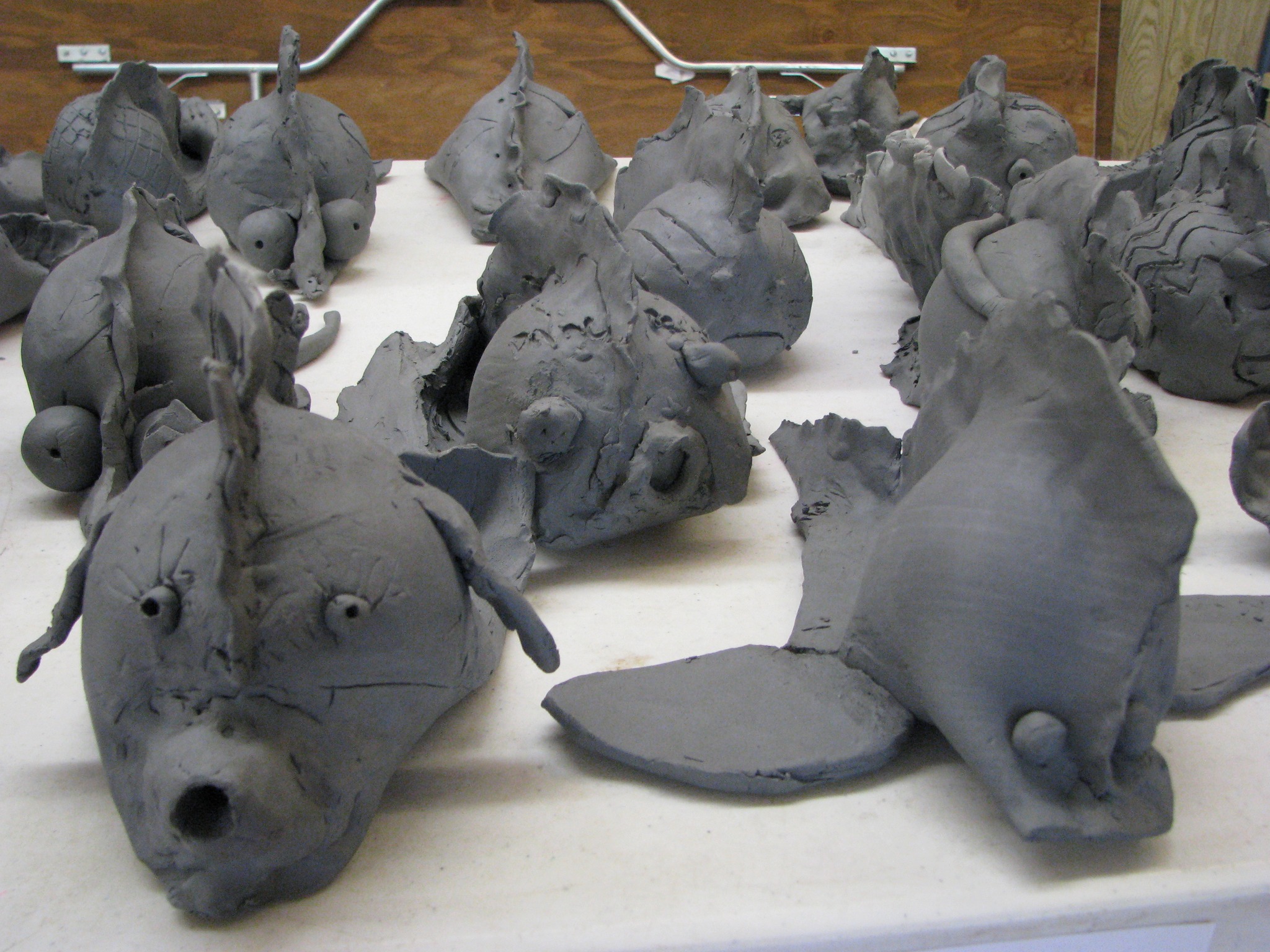 Hand-built clay creatures drying in the studio