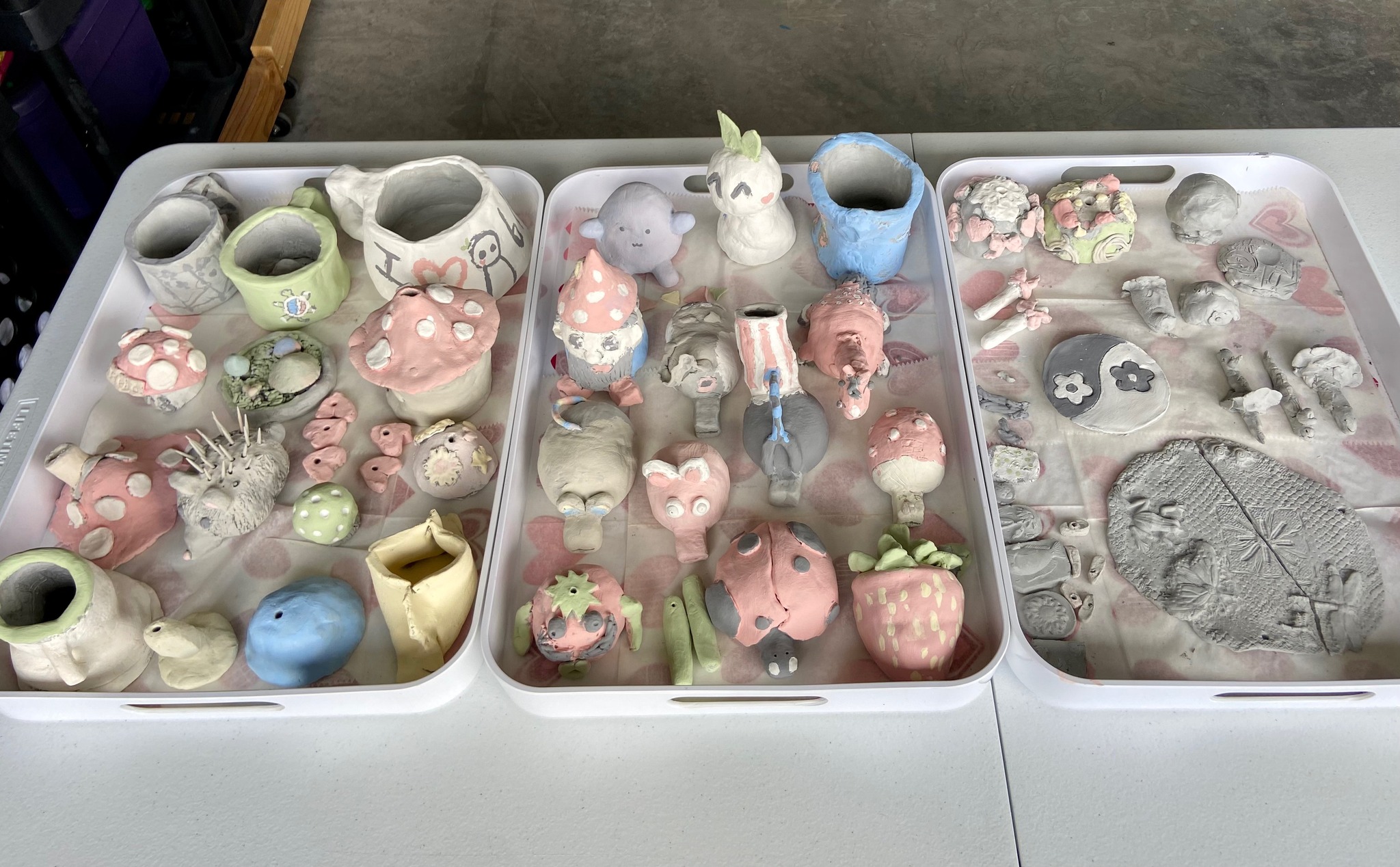 Pastel-painted pinch pots and clay creatures by Planet Picasso students