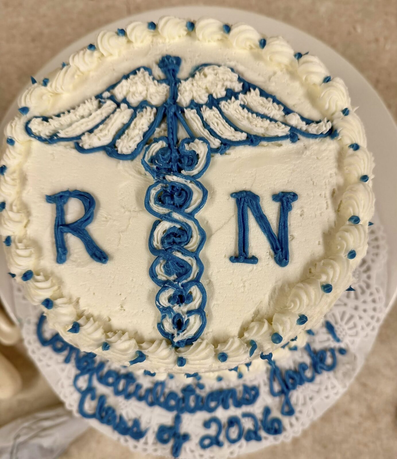 Graduation cake piped with a nursing caduceus and RN