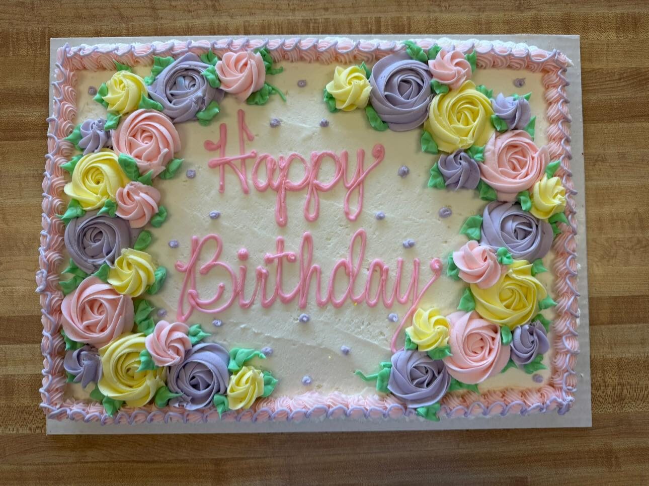 Sheet cake bordered with colorful piped buttercream roses