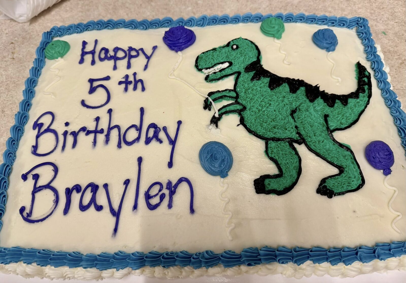 Kids' birthday sheet cake with a green T-rex