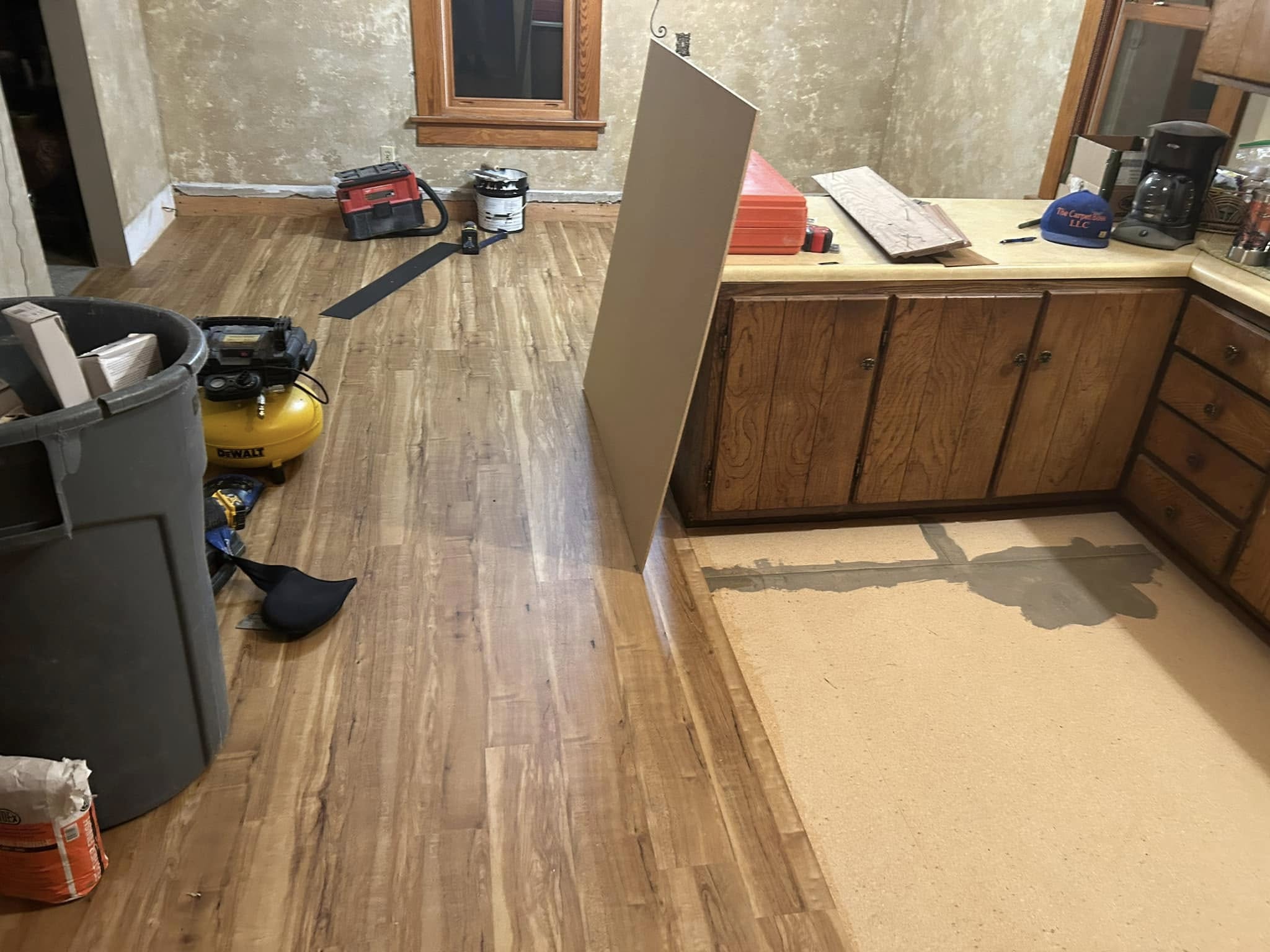 Renovation in progress with installed wood flooring and cabinetry