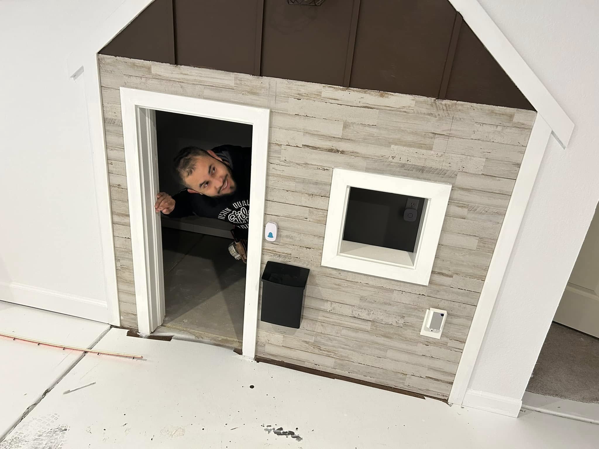 Custom-built under-stair playhouse with person visible inside