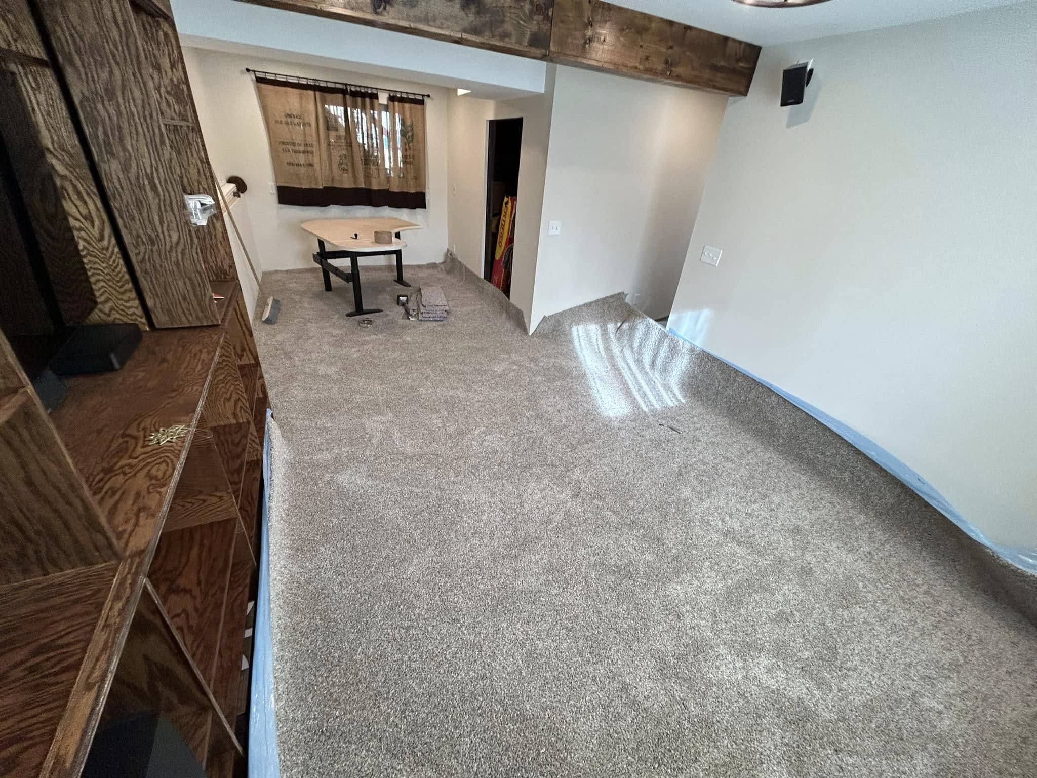 Living space with light gray carpet, wood features, and built-in shelving