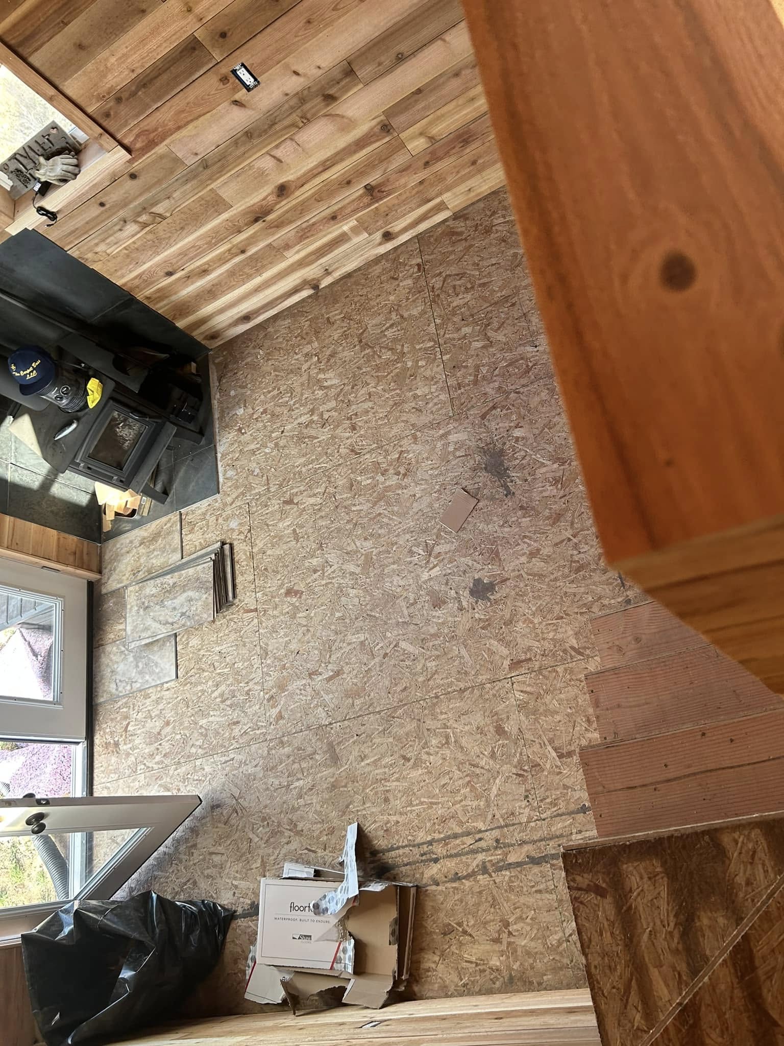 Renovation in progress with mixed flooring and exposed framing